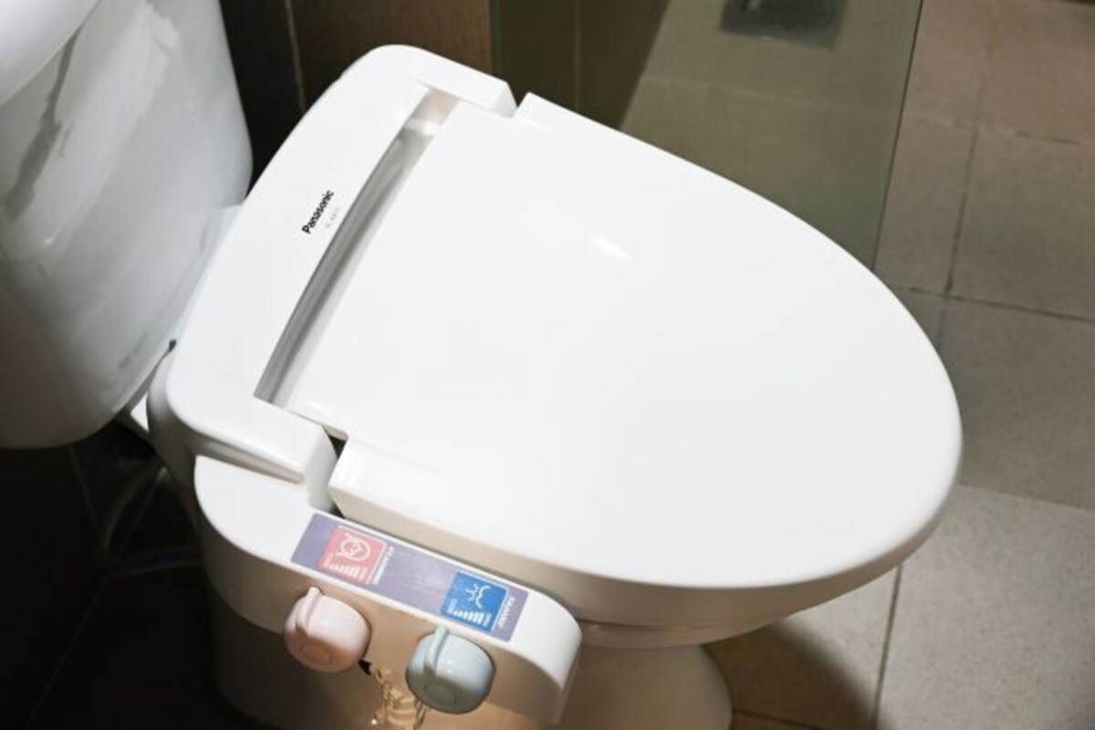 Un inodoro con un panel de control que incluye un botón de descarga y función de bidé.