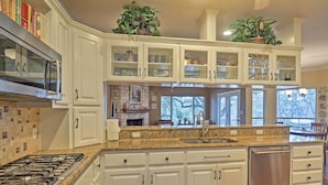 A kitchen with white cabinets, a granite countertop, a Bosch microwave, and a dishwasher. - Round Rock Lakefront Home w/ Water Toys & Fire Pit (Round Rock)