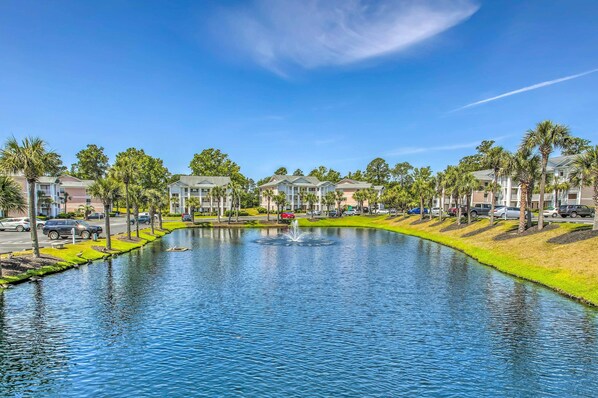 Un quartier résidentiel avec un canal, des maisons et des voitures garées.