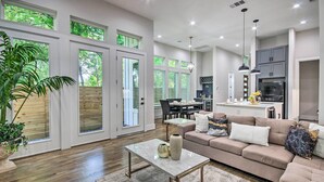 A spacious living room with a large sofa, a coffee table, and a dining area. - Game Day Ready Home: 2 Mi to Dtwn Houston (Houston)