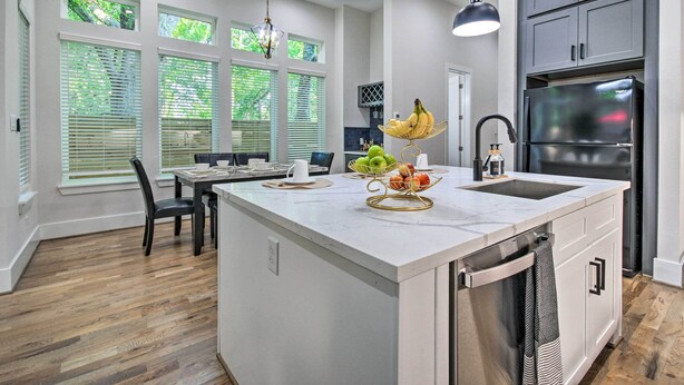 A modern kitchen with a central island, white cabinetry, and a stainless steel refrigerator. - Game Day Ready Home: 2 Mi to Dtwn Houston (Houston)