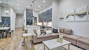 A spacious living area with a large sectional sofa, a coffee table, and a dining area with a table and chairs. - Game Day Ready Home: 2 Mi to Dtwn Houston (Houston)