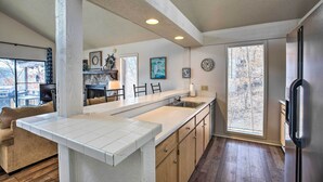 A modern kitchen with a large island, wooden cabinets, and a built-in refrigerator.