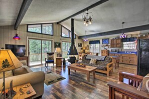 A spacious living room with a fireplace, a sofa, a coffee table, and a television. - Quiet Cabin w/ Mountain Views ~ 3 Mi to Gatlinburg (Gatlinburg)