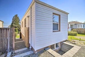 Ein Bungalow mit einer kleinen Veranda und einem Fenster mit Jalousien.
