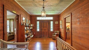 A wooden interior with a staircase, a bookshelf, and a door leading to another room. - Historic 1840's Estate on 20 Acres w/ Guest House (Lafayette)