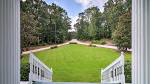 A view from a porch overlooking a well-manicured lawn with a pathway leading to a building. - Historic 1840's Estate on 20 Acres w/ Guest House (Lafayette)