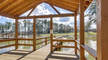 A wooden deck with a view of a lake and trees.