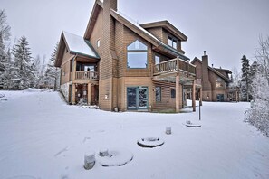 Een ruime houten lodge met meerdere balkons en een besneeerd landschap.