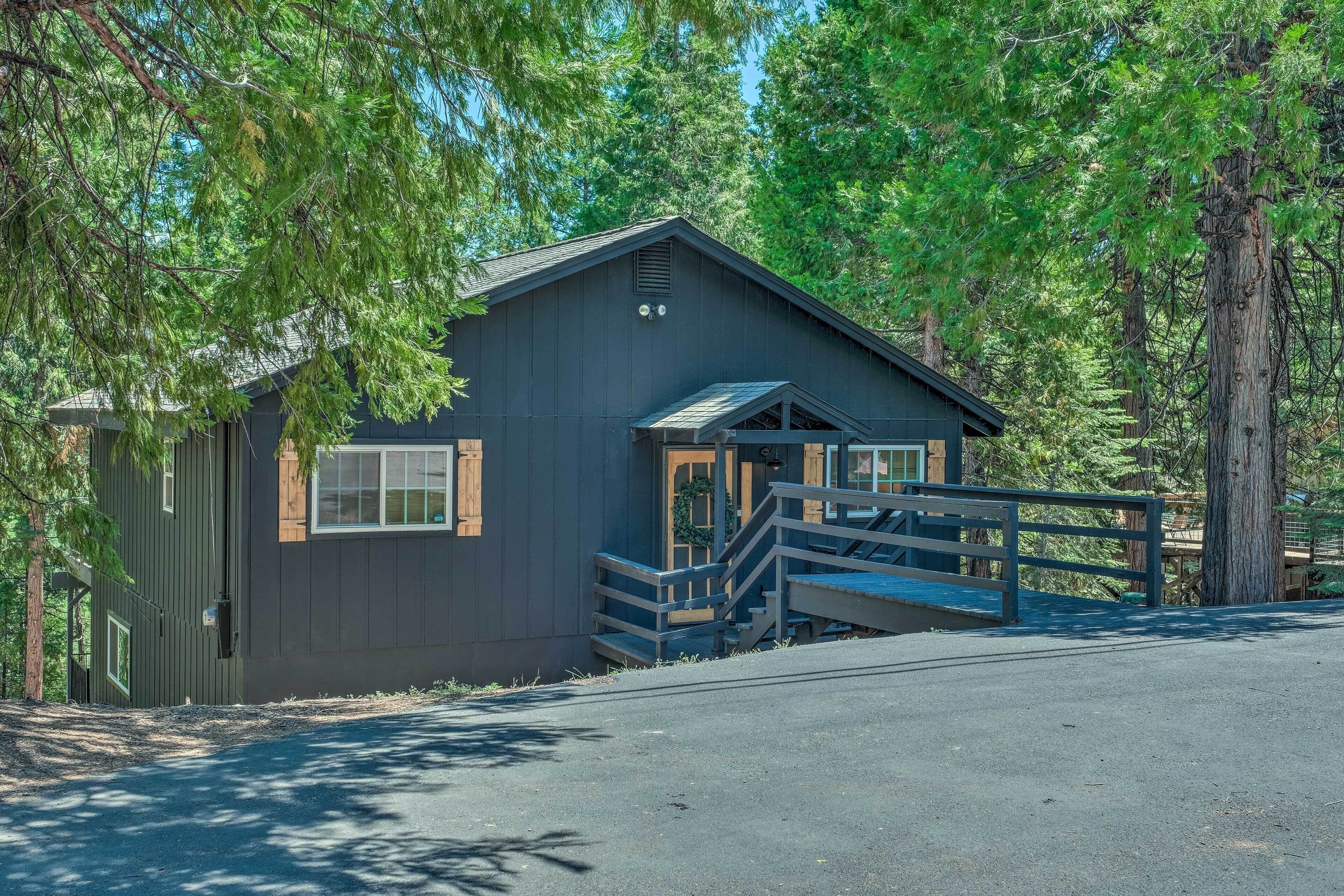A cabin with a wooden deck and stairs leading to the entrance.