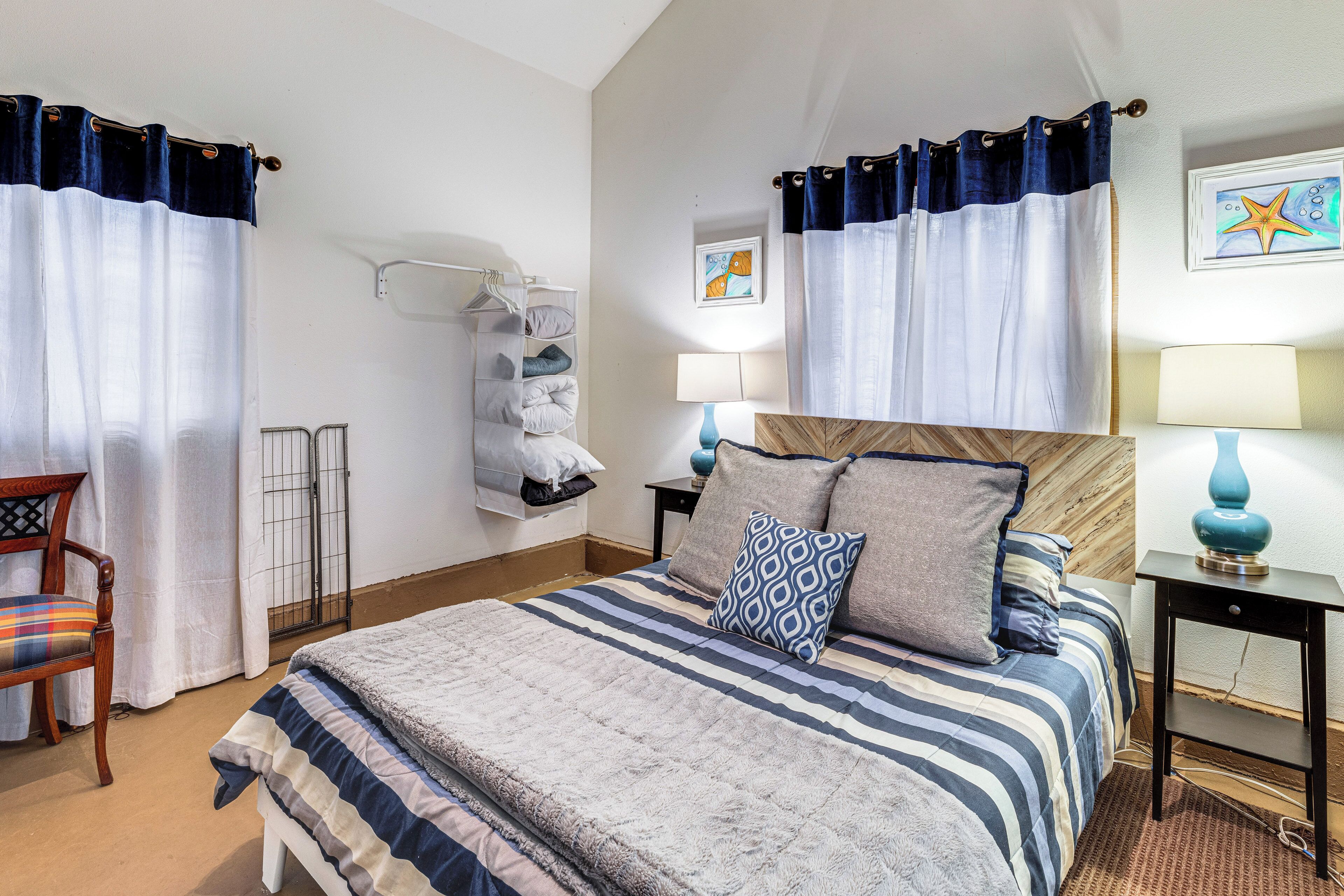 Una camera da letto ordinata con un letto, comodini, una sedia e un armadio.