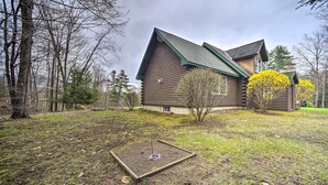 A log cabin with a sloped roof, surrounded by a grassy yard and trees. - Lovely Fort Ann Lodge - 10 Mi to Lake George! (Fort Ann)