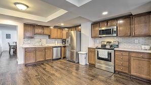 A modern kitchen with wooden cabinets, stainless steel appliances, and a tiled backsplash. - Family-friendly Millville Home < 8 Mi to Town (Millville)