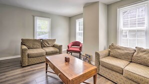 A living room with two patterned sofas, a wooden coffee table, and a red chair. - Family-friendly Millville Home < 8 Mi to Town (Millville)