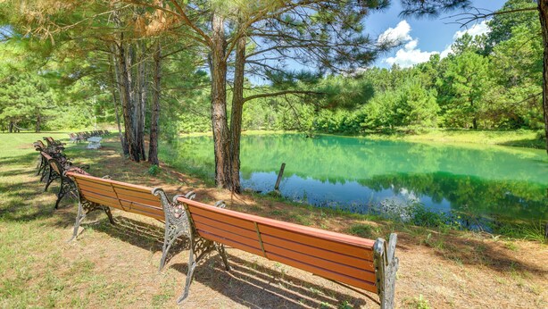 A park with a bench, a pond, and trees. - Private Pool: Spacious & Secluded Magnolia Cottage (Magnolia)