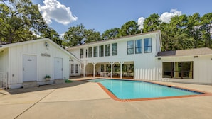 A two-story house with a swimming pool, a covered patio, and a fenced yard. - Private Pool: Spacious & Secluded Magnolia Cottage (Magnolia)