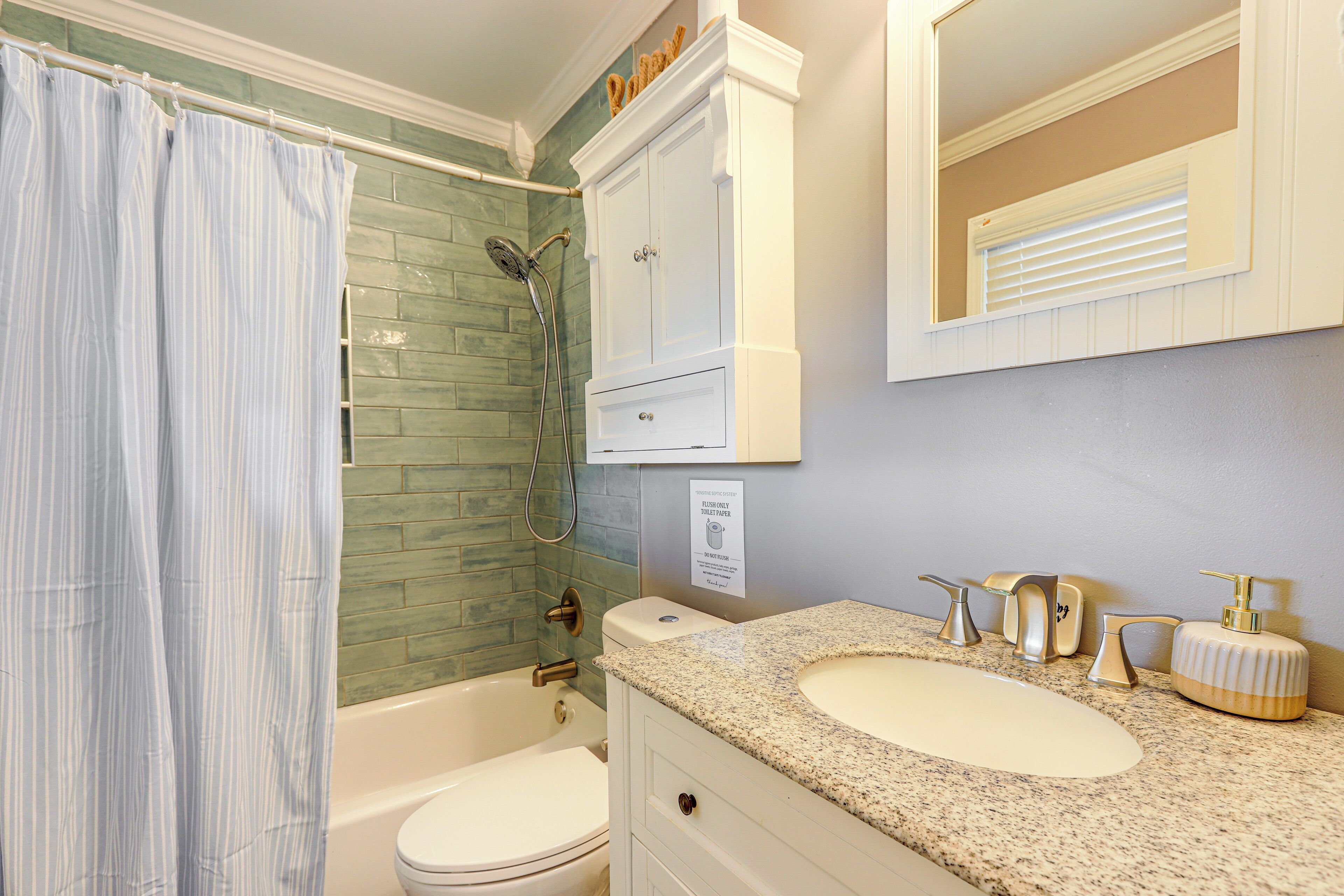 A bathroom with a shower, toilet, and sink.