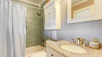 A bathroom with a shower, toilet, and sink.