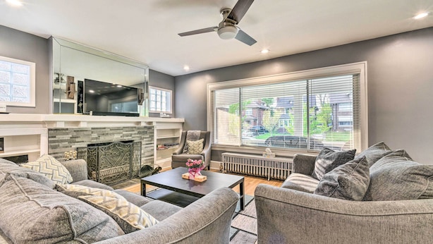 A modern living room with a gray sofa, a coffee table, and a fireplace. - Elegant Detroit Home w/ Yard ~ 5 Mi to Dtwn! (Detroit)