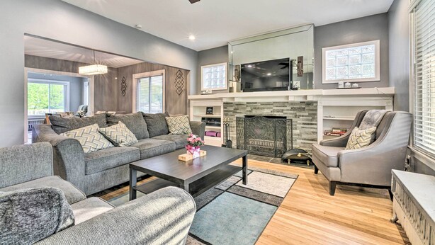 A modern living room with a grey sofa set, a coffee table, and a fireplace. - Elegant Detroit Home w/ Yard ~ 5 Mi to Dtwn! (Detroit)