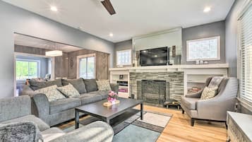 Un salon moderne avec un canapé gris, une table basse et une cheminée.