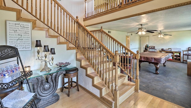 A multi-level wooden staircase with a glass table and chairs at the bottom landing. - Large Home w/ Games: 4 Mi to Bull Shoals Lake! (Lakeview)