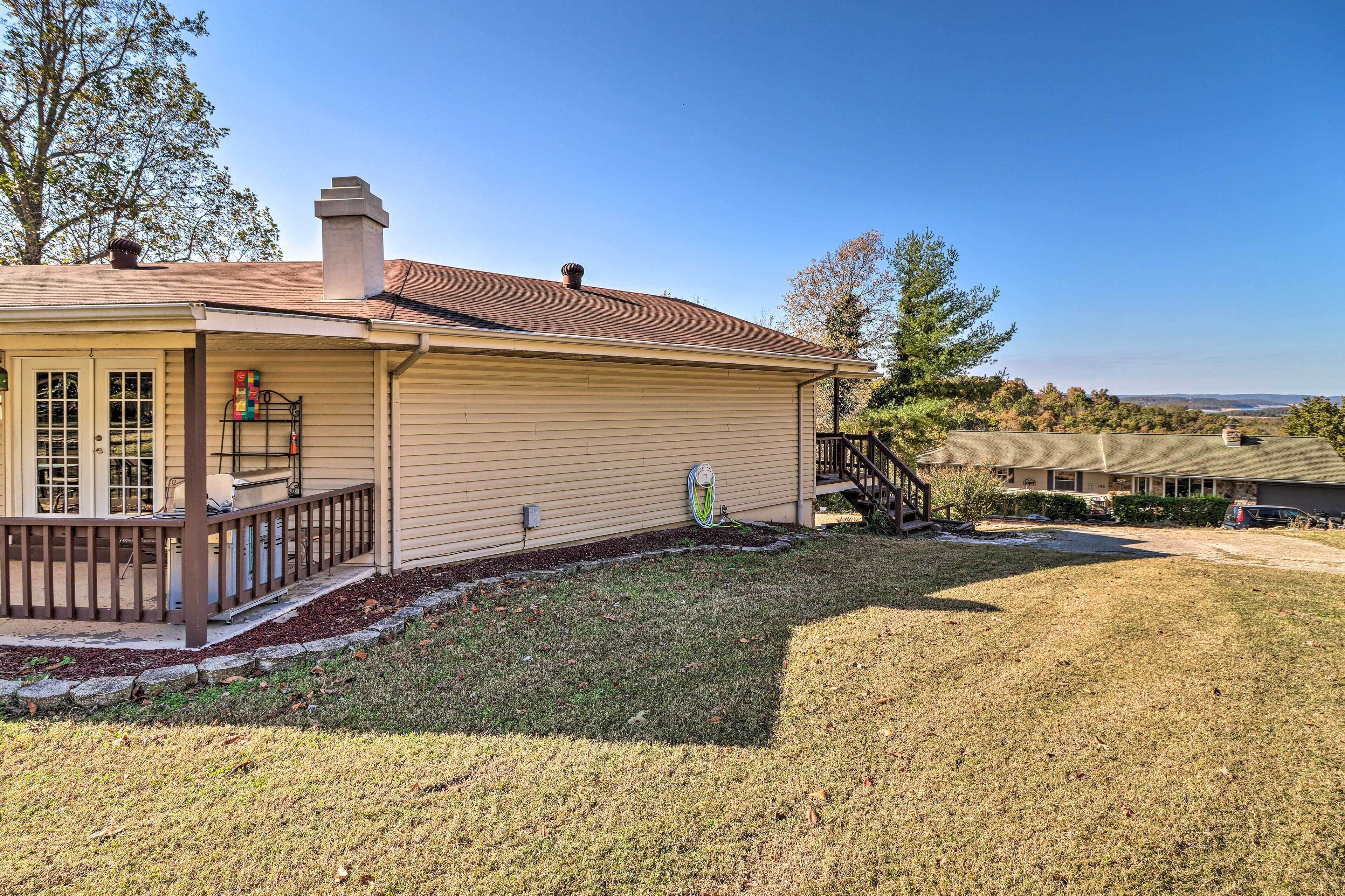 A single-story house with a covered porch, a chimney, and a view of the surrounding landscape.