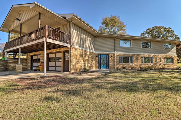Relax on the upper-floor balcony with a view of the well-maintained lawn.