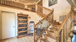 A wooden staircase with a handrail, a door, and a display cabinet with glass doors. - Large Home w/ Games: 4 Mi to Bull Shoals Lake! (Lakeview)