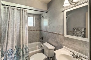 Features a large bathtub, separate toilet, and sink.