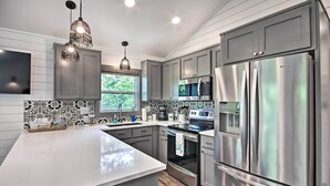 Una cocina moderna con armarios grises, electrodomésticos de acero inoxidable y una isla grande.