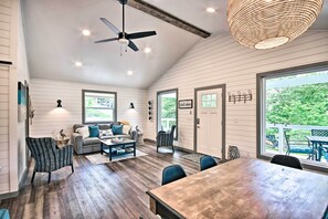 A spacious room with a dining table, a sofa set, and a ceiling fan. - Grand Lake Cottage w/ Hot Tub in Eucha (Eucha)