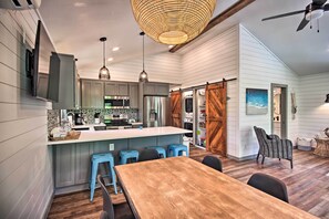 A modern kitchen with a central island, bar stools, and a dining table. - Grand Lake Cottage w/ Hot Tub in Eucha (Eucha)