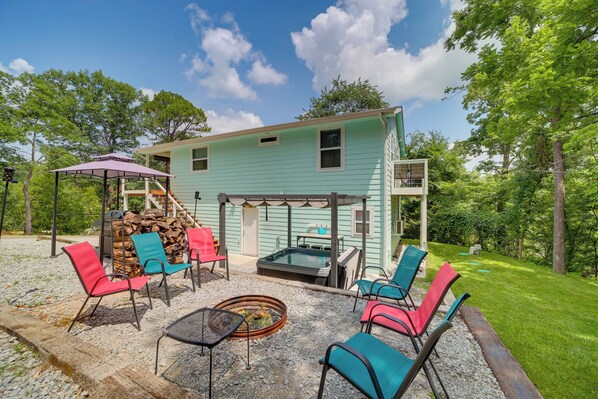 A light blue house with a covered patio area featuring outdoor seating and a hot tub. - Grand Lake Cottage w/ Hot Tub in Eucha (Eucha)