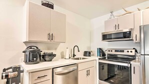 Een moderne keuken met roestvrijstalen apparatuur, waaronder een magnetron, oven en vaatwasser.