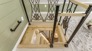 A wooden staircase with metal railings and a handrail. - Killingly Barnyard Studio in Wine Country! (Dayville)