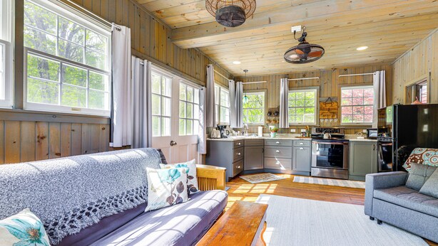A cozy cabin interior with a sofa, a bench, a dining table, and a kitchen area. - Killingly Barnyard Studio in Wine Country! (Dayville)
