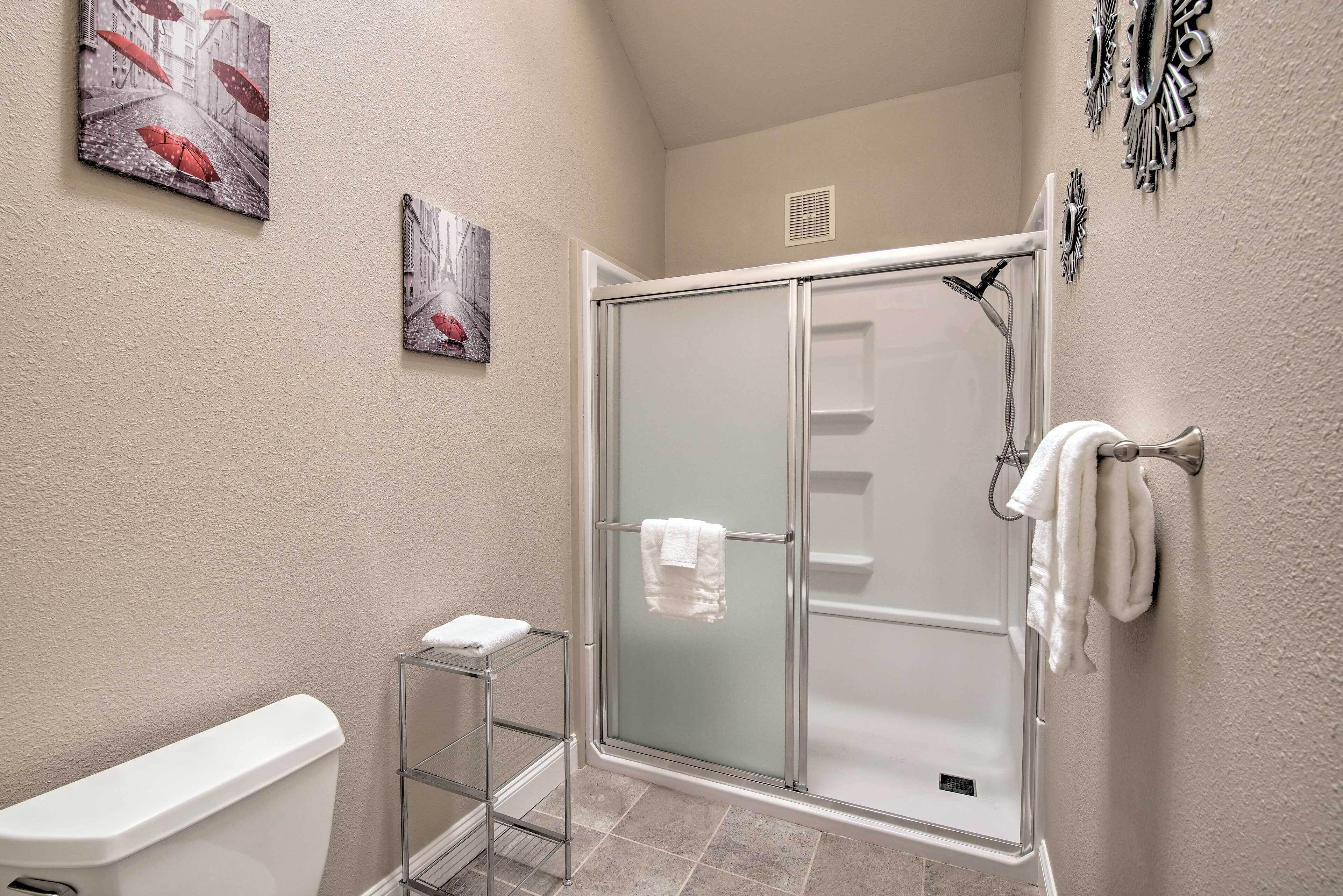 Een badkamer met een douchecabine van glas, een toilet en een handdoekhouder.