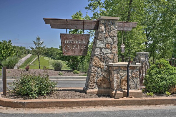 A stone pillar with a sign reading "TAN-TARA ESTATES" and a well-maintained lawn in the background. - Getaway w/ Hot Tub in Margaritaville Lake Resort! (Osage Beach)
