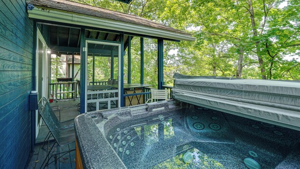 Un espace bien-être comprenant un jacuzzi, des sièges extérieurs et une terrasse couverte.