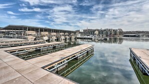 Un port de plaisance avec des bateaux amarrés, un grand bâtiment portant une enseigne et une étendue d’eau calme.