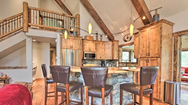 A rustic kitchen with stone countertops, wooden cabinets, and a bar area with leather barstools. - 5 Mi to Crescent Lake: Dog-friendly Oregon Getaway (Crescent)