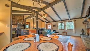 A spacious living area with a wooden dining table, a sofa, and a fireplace. - 'stonewood Lodge' Couples Retreat in Glenville! (Glenville)