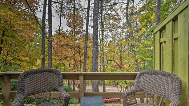 A wooden deck with wicker chairs and a small table, surrounded by trees with autumn foliage. - 'james West' Apt w/ 50 Acres Near Raystown Lake (Huntingdon)