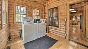A log cabin interior with a washing machine, dryer, and a large window. - Riverfront Lewiston Cabin w/ Stone Fireplace! (Mio)
