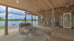 A covered outdoor area with a grill, seating, and a view of a lake. - Secluded Angler's Haven - Boat + Fish! (Rosston)