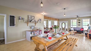 A spacious living area with a wooden dining table, benches, and a cozy seating area with a sofa and armchairs. - Secluded Angler's Haven - Boat + Fish! (Rosston)