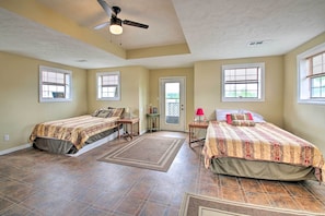 A bedroom with two beds, a ceiling fan, and a door leading outside. - Secluded Angler's Haven - Boat + Fish! (Rosston)