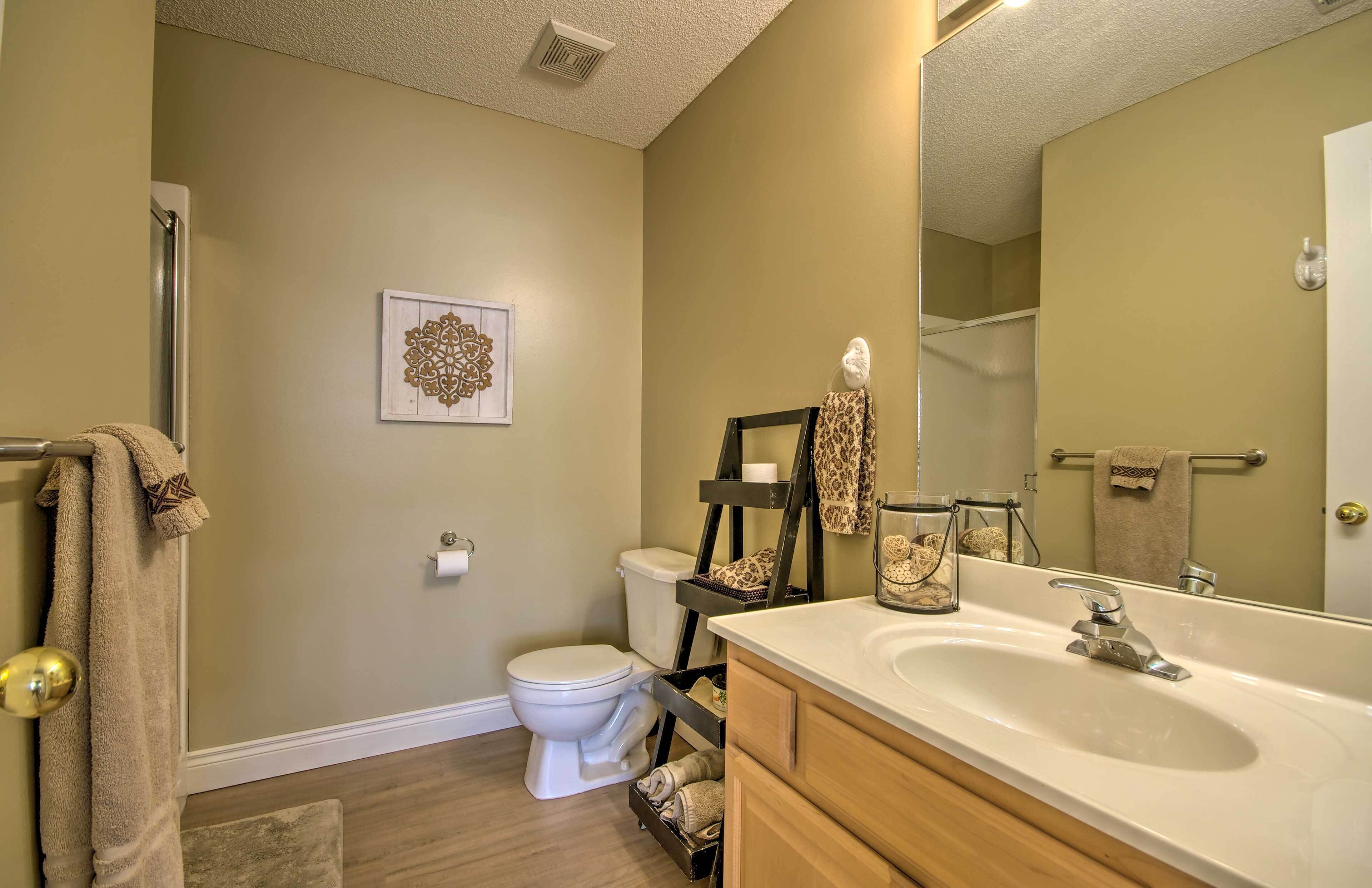 A bathroom with a toilet, sink, and shower.