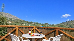An outdoor dining area with a table, chairs, and a bottle of wine. - Cozy Apartment El Pajar near El Chorro (El chorro)